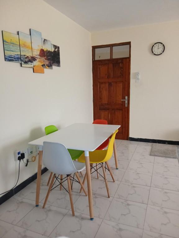 a dining room with a white table and chairs at Anuka Luxury in Mombasa