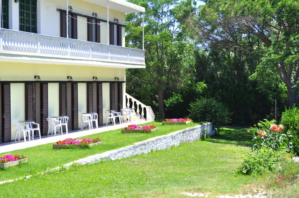 a house with chairs and flowers in the yard at Family Studios in Marathias