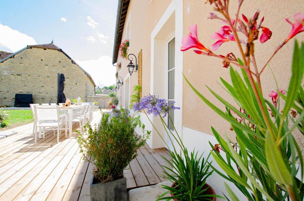 a patio with a table and chairs and flowers at Le clos de la ferme 