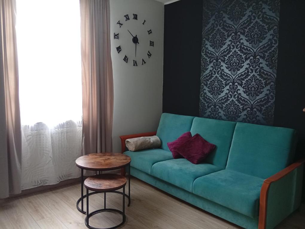 un sofá verde en una sala de estar con un reloj en la pared en Lena, en Gdansk