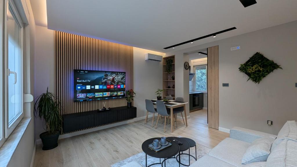 a living room with a couch and a tv on a wall at The Central Spot, Mostar in Mostar