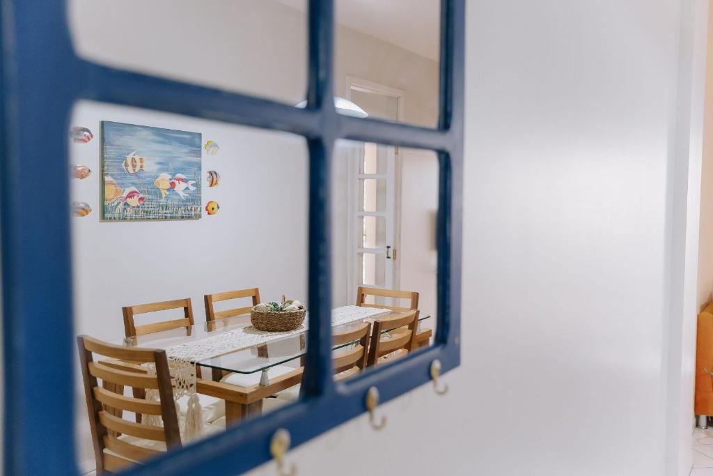 a dining room with a table and chairs through a window at Recanto dos Corais - Praia do Gravatá - Navegantes in Navegantes