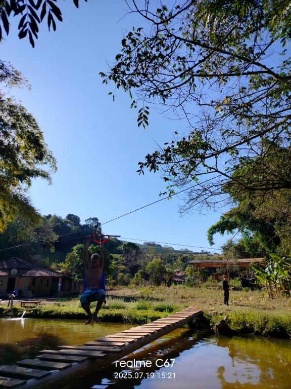a man hanging from a rope over a river at Paraíso dás águas in Botelhos