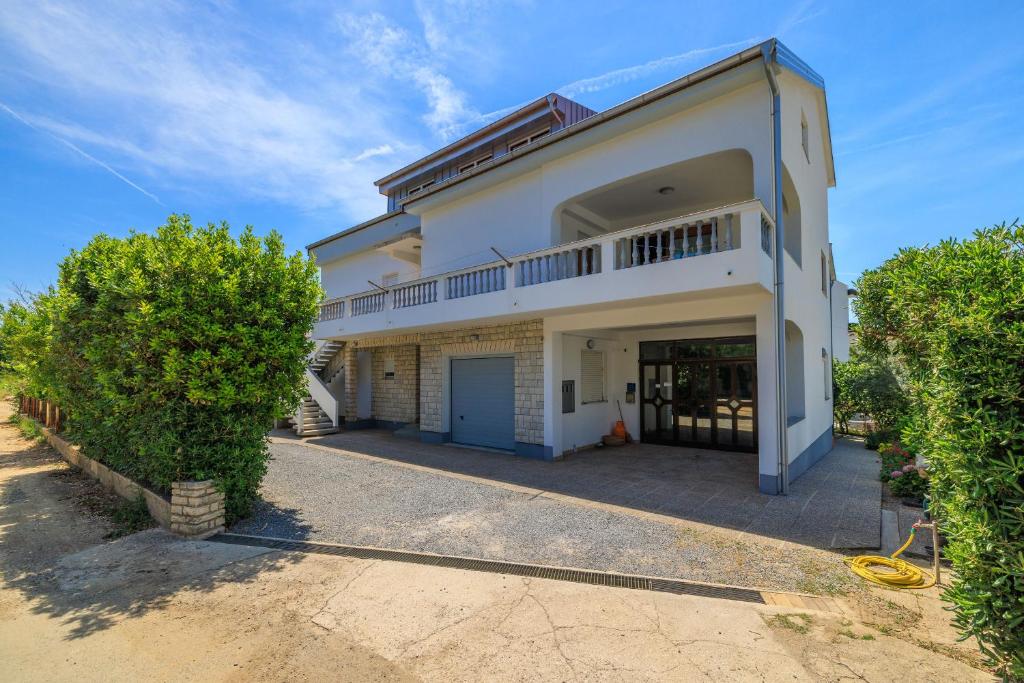a large white house with a garage at Apartments Slavica R in Banjol