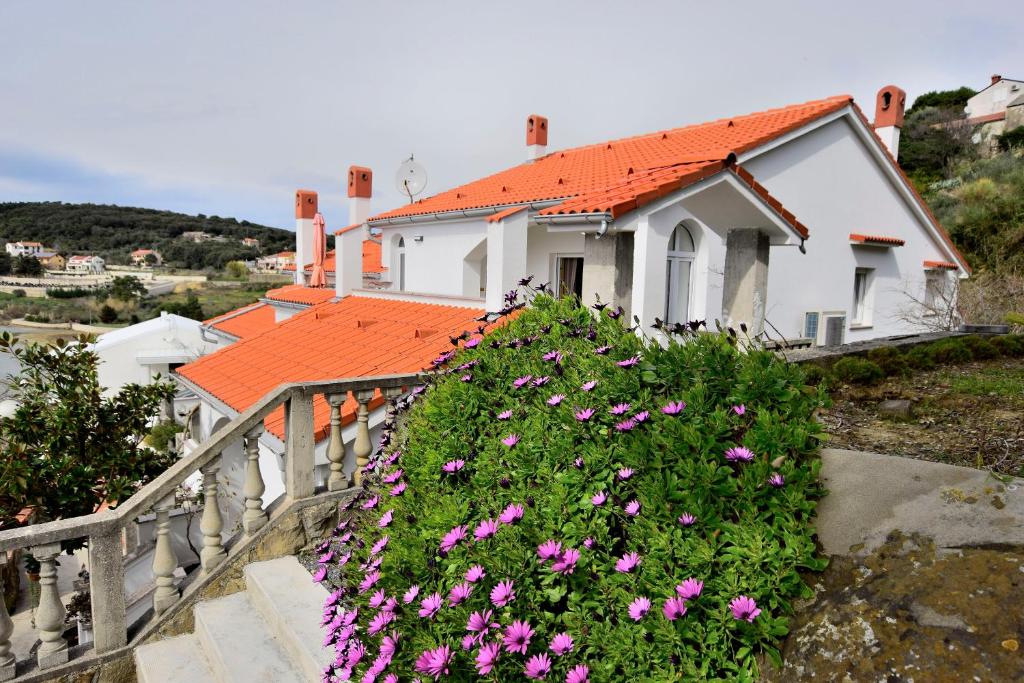 une maison avec des fleurs roses devant elle dans l'établissement Apartment Vidas, à Palit