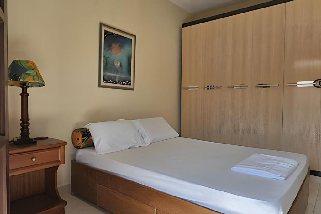 a bedroom with a bed with a closet and a door at Acesso a Praia com Área Gourmet in Saquarema