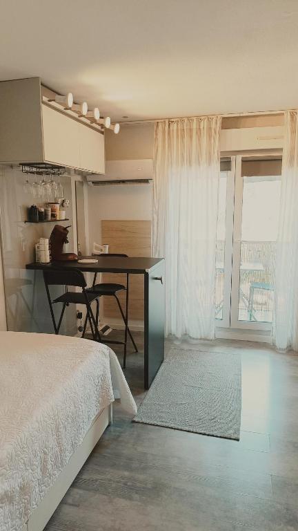 une chambre avec un lit et une table et une cuisine dans l'établissement MANHATTAN Studio climatisé Balcon Ensoleillé Parking proche Montpellier, à Grabels