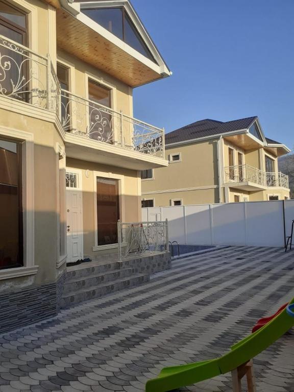a large building with a patio and a fence at Twin villas VSL in Gabala