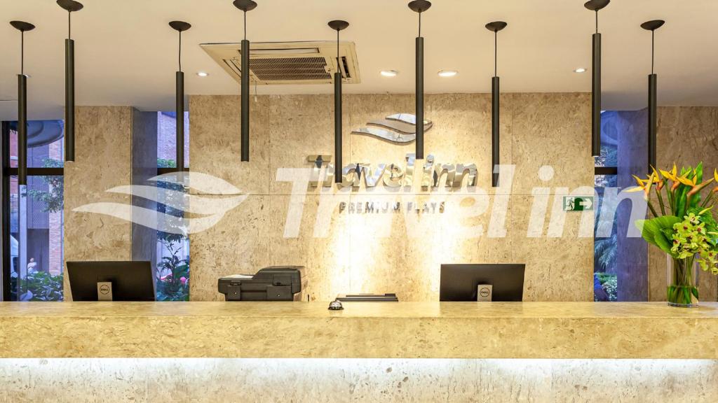 a lobby with a counter and chairs and a bar at Travel Inn Premium Flats Paulista Wall Street in Sao Paulo