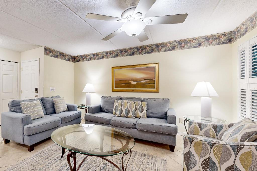 フェルナンディーナ・ビーチにあるGround-floor summer beach village condo with a great view plus patio & poolのソファとテーブルのあるリビングルーム