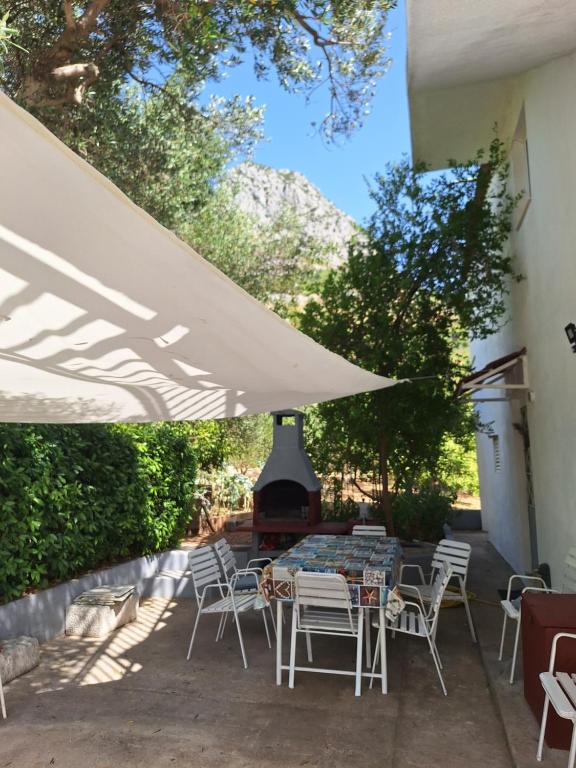 a patio with a table and chairs and a fireplace at Studio apartmani Ante in Zaostrog