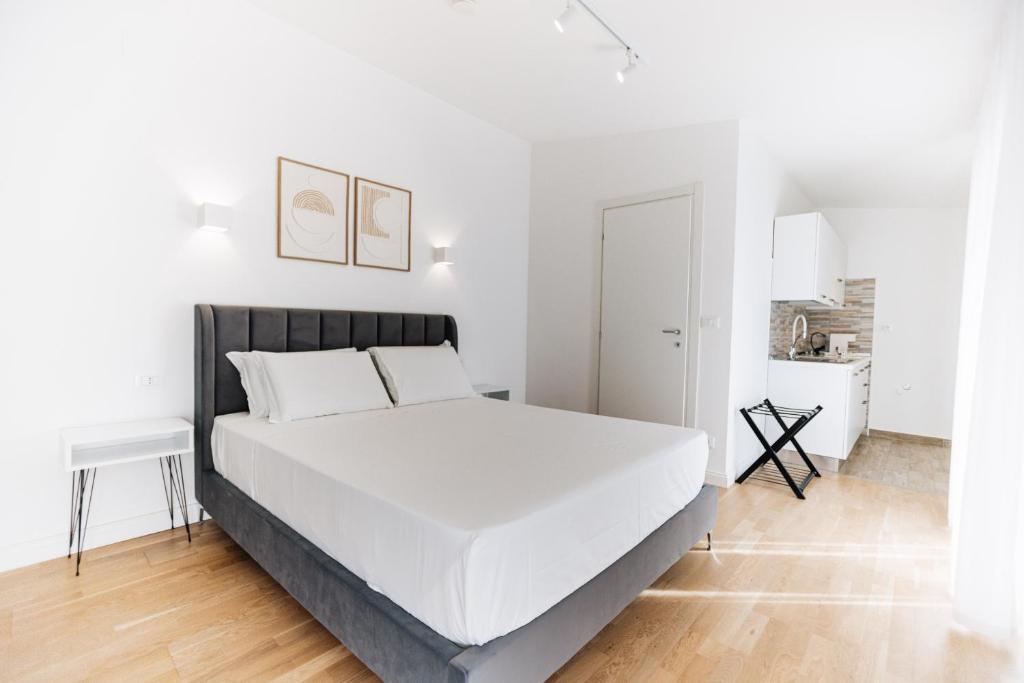 a white bedroom with a large white bed in it at Centoquindici Rooms & Suite in Montesilvano