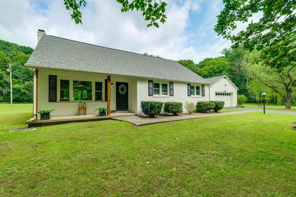 a white house with a large yard at Alleghany Mountain Cottage with Porch and Backyard in Covington