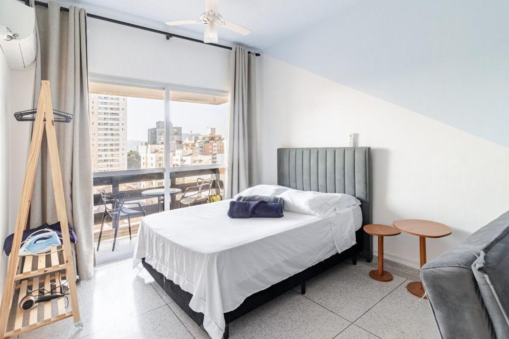 a bedroom with a bed and a large window at Vista para o Mar & Pé na Areia in São Vicente