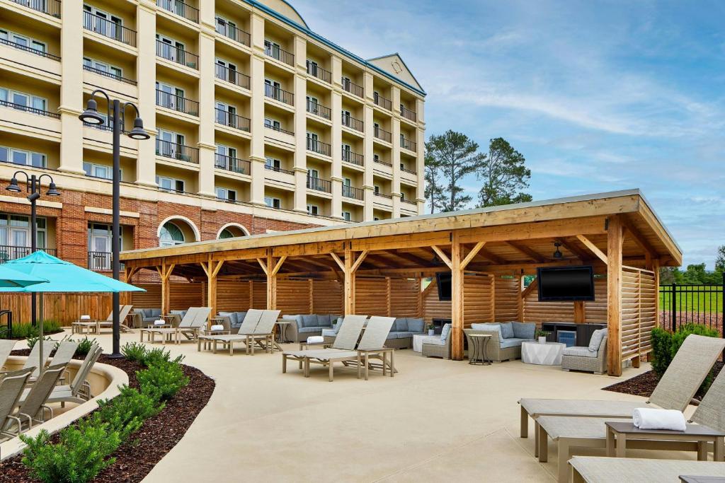 a hotel patio with lounge chairs and a large building at Renaissance Shoals Resort & Spa in Florence