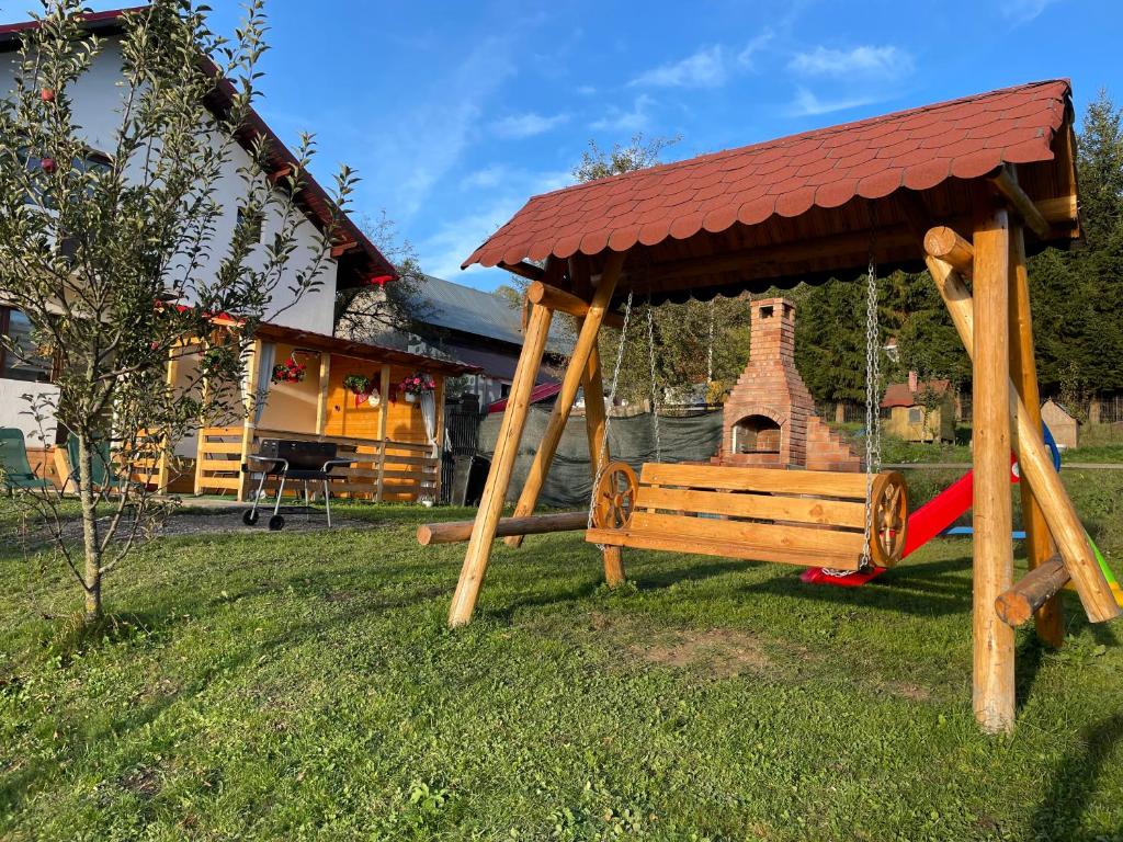 a swing set in a yard with a house at Cozy mountain house in Trăisteni