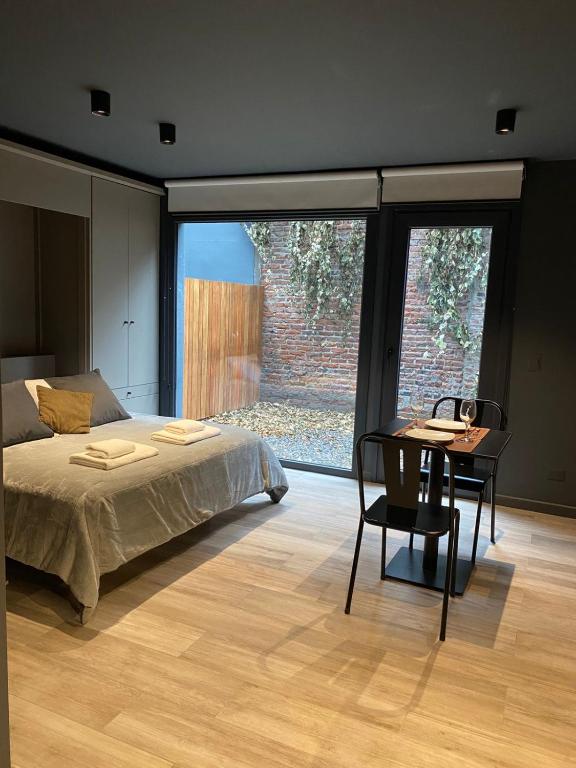 Schlafzimmer mit einem Bett und einem Schreibtisch mit einem Tisch in der Unterkunft Edificio Pantera - monoambiente 7 in San Martín de los Andes