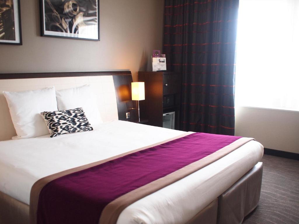 a bedroom with a large bed with a purple blanket at Mercure Angers Centre Gare in Angers