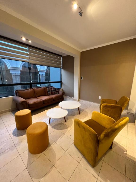 ein Wohnzimmer mit Sofas, Tischen und einem Sofa in der Unterkunft Apto de 2 habitaciones en el centro de Tarija! in Tarija