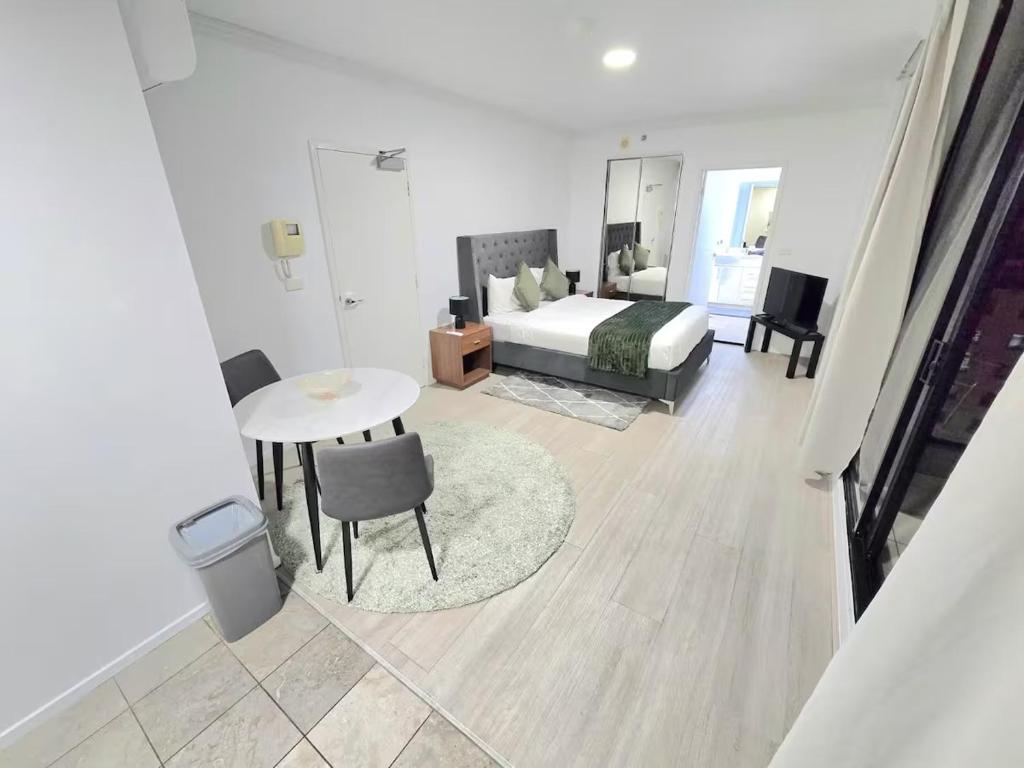 a bedroom with a bed and a table and chair at Modern Studio Apartment near ICC On Dixon street in Sydney