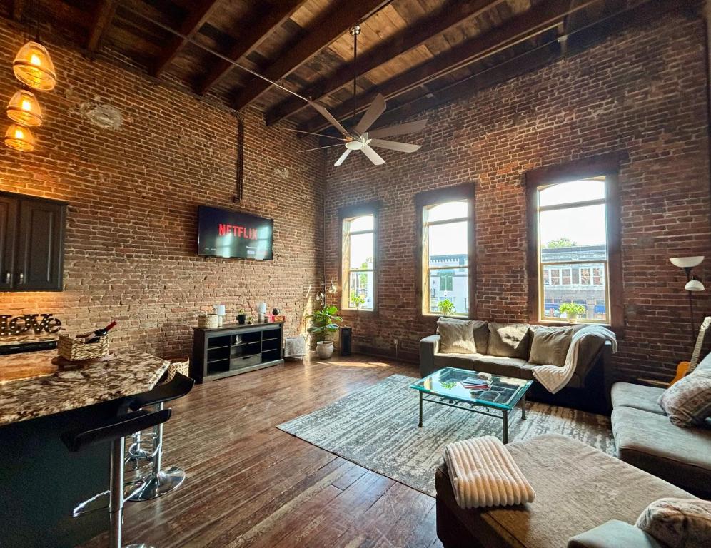a living room with a brick wall and a ceiling at In the Heart of Town-3BR-2bath-500Mbps WiFi-4car parking-EV-boat in Florence