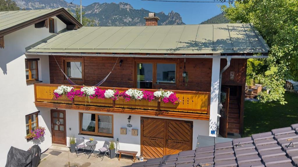 a house with a balcony with flowers on it at Schlafende Hexe in Bischofswiesen
