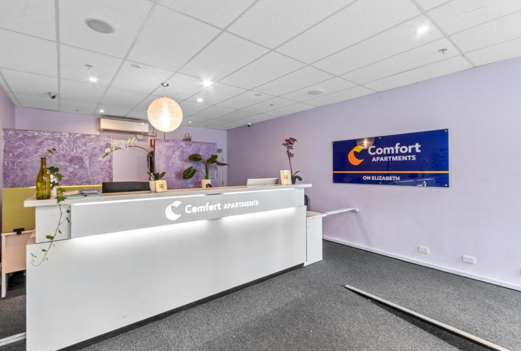 an office with a counter and a sign on the wall at Comfort Apartments on Elizabeth in Melbourne