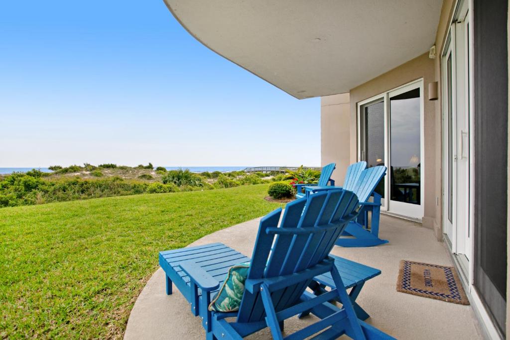 tres sillas azules sentadas en el porche de una casa en Luxe, Updated, Oceanfront Condo with Ground-Floor Patio, WiFi & Shared Pool, en Amelia Island