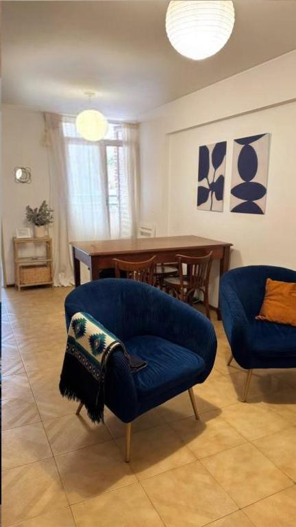 un salon avec une chaise bleue et une table dans l'établissement Ayacucho loft, à Córdoba