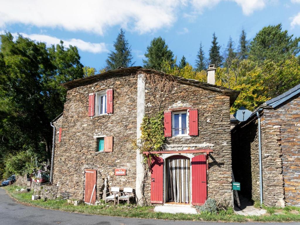 an old stone house with red doors and windows at Cevennes Stone Retreat in Saint-Germain-de-Calberte