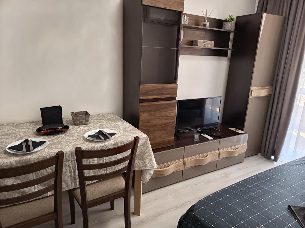 a dining room with a table and a tv at Hotel Rooms St Paul Central Plovdiv Self Check-in Budget Stay in Plovdiv