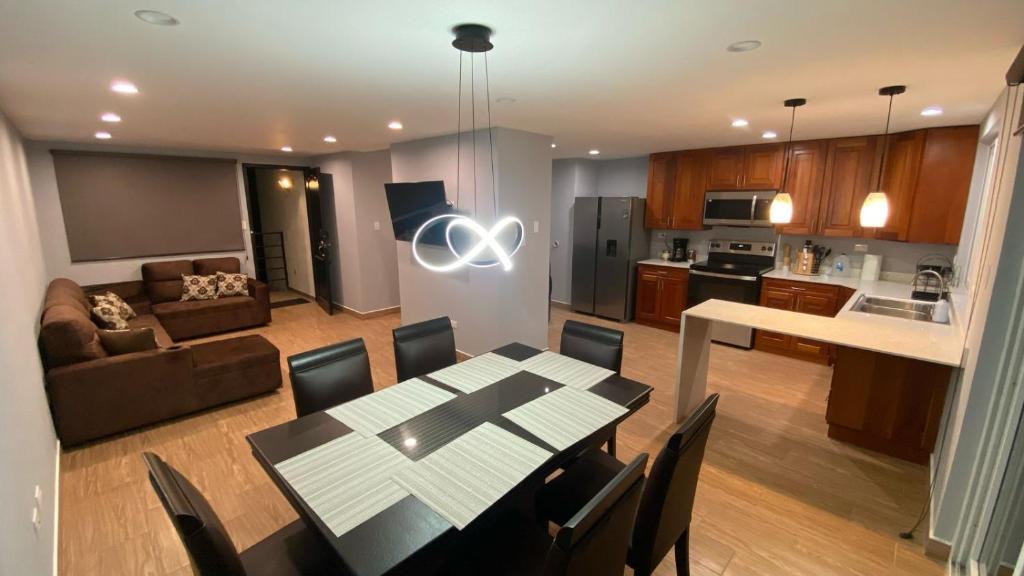 a kitchen and a living room with a table and chairs at Cozy Modern 3 Bedroom Apartment in Guatemala City in Santa Rosita