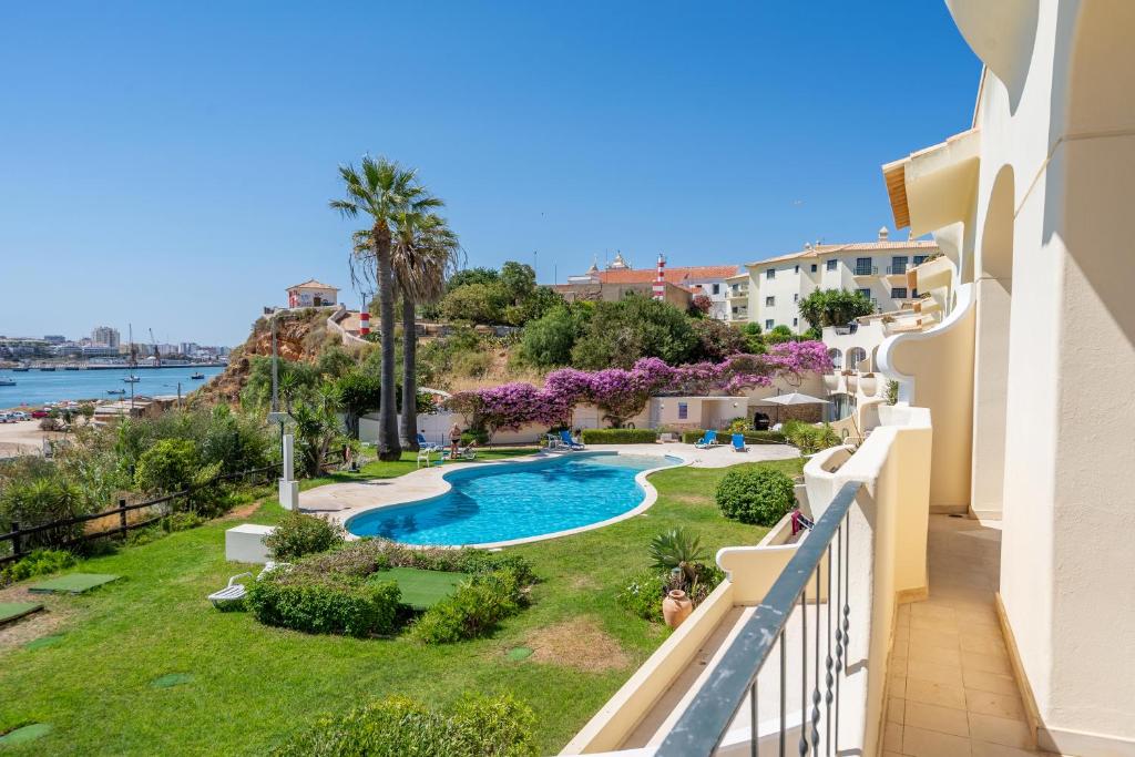 Una vista de la piscina desde el balcón de un apartamento. en Sol e Praia - Ferragudo, en Ferragudo