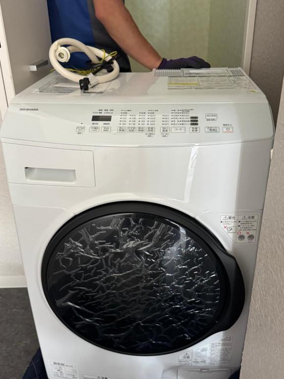a person standing next to a washing machine at househotel上野 入谷 in Tokyo