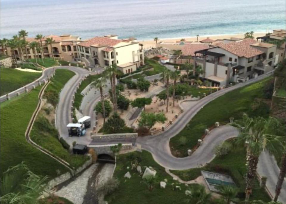 Montecristo Villa at Quivera Los Cabos Vacation Rental في كابو سان لوكاس: طريق متعرج أمام منزل بالقرب من الشاطئ