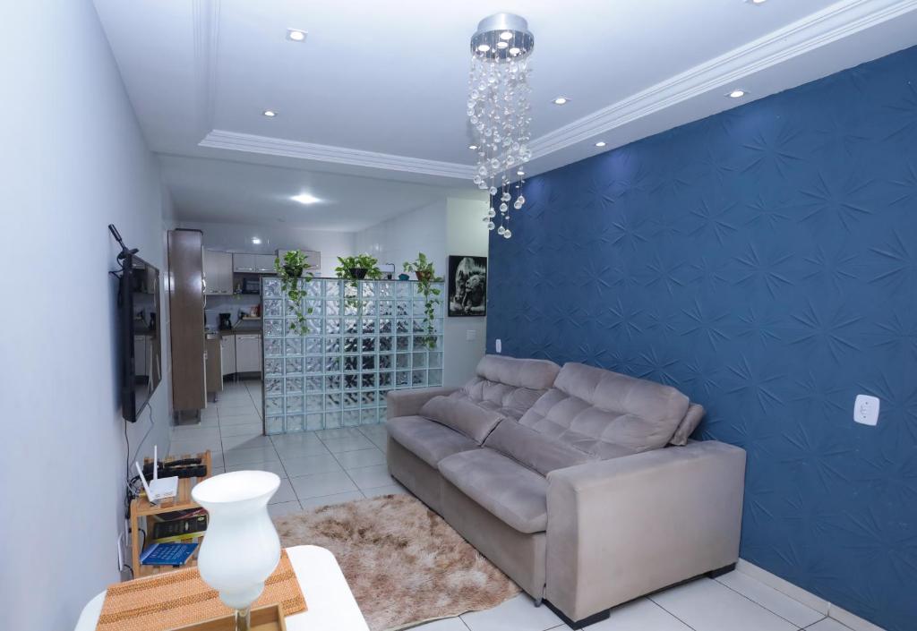 salon z kanapą i niebieską ścianą w obiekcie Apartamento aconchegante ideal para casais w mieście Campos dos Goytacazes