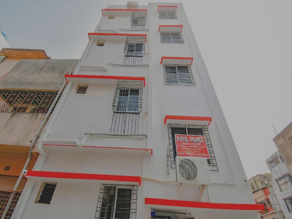 a white building with red windows and a sign on it at Hotel O Royal Palace in Kolkata