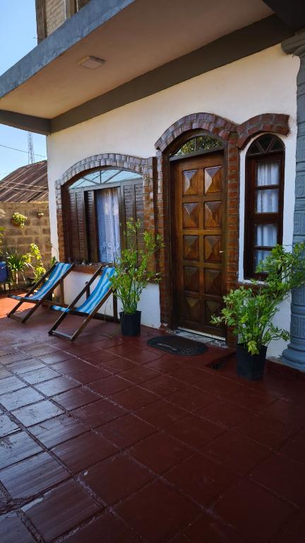 a house with a porch with a door and plants at Flor de Lis in Puerto Iguazú