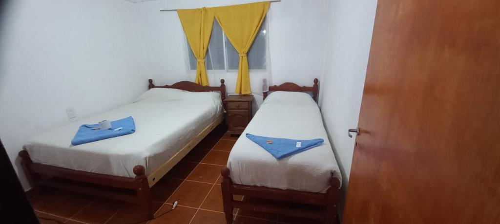 two beds in a room with blue towels on them at Hostal el rincón de cusi in Mina Pirquitas