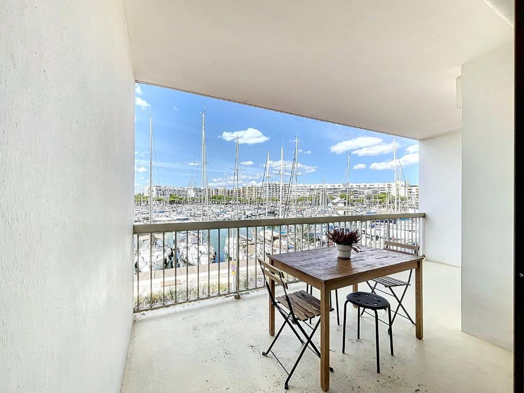 un balcon avec une table et des chaises et une vue sur un port dans l'établissement Appartement T2 avec piscine, tennis, proche port et plage, 4 couchages, Carnon - FR-1-715-33, à Mauguio