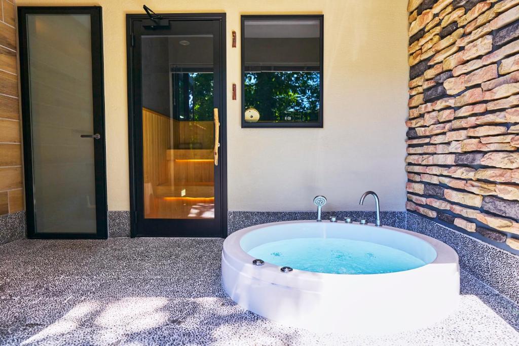 a bath tub in front of a building with a door at The BEITH in Saku