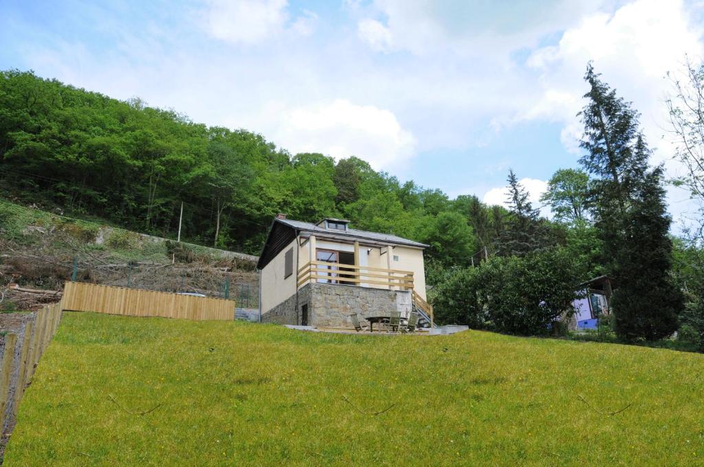 une petite maison au sommet d'une colline herbeuse dans l'établissement Chalet d'Aventures, à Durbuy