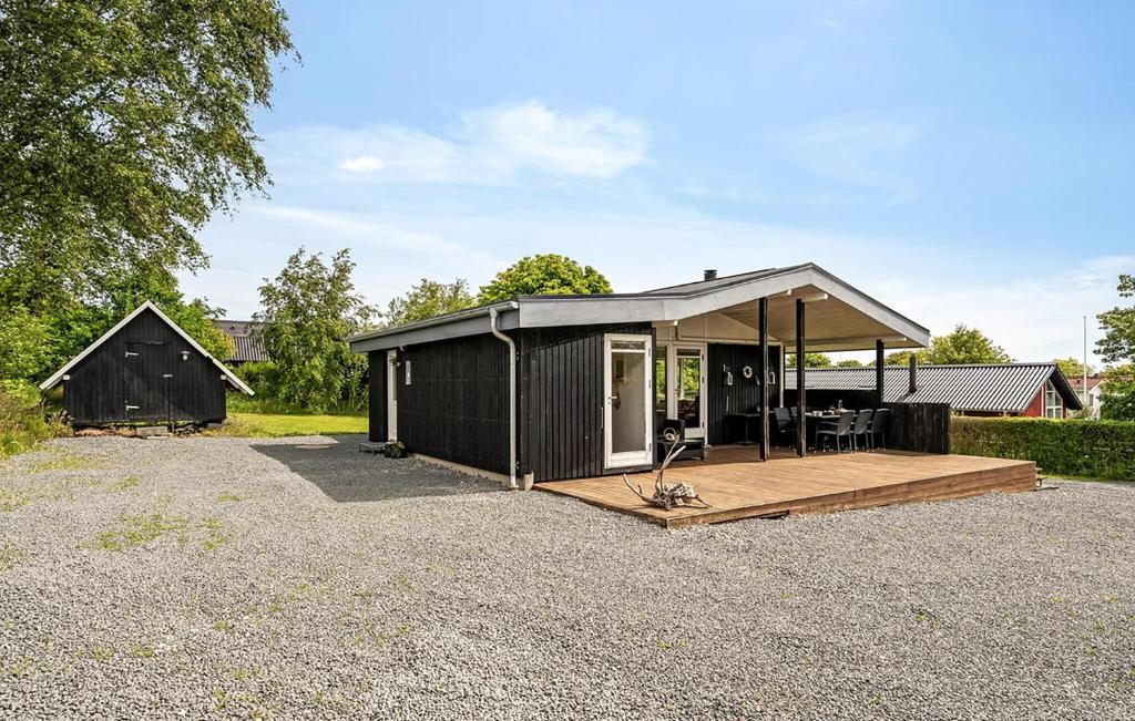 a black shed with a porch and a deck at 3 Bedroom Nice Home In Roslev in Roslev