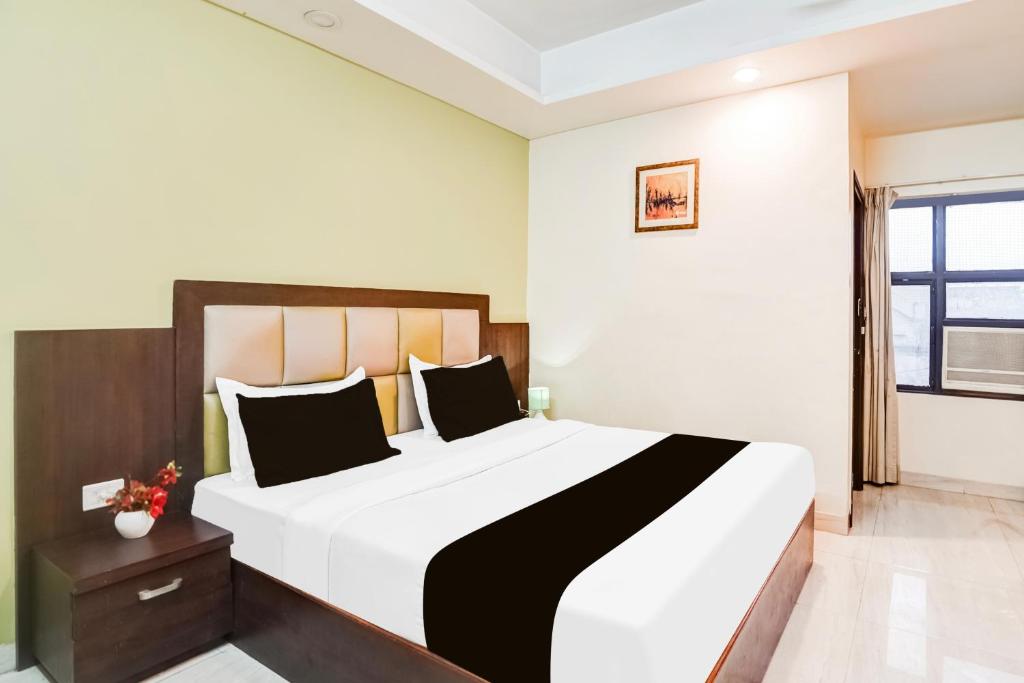 a bedroom with a large bed and a window at Super Townhouse Sikar Road Jaipur Formerly Hotel Aroma Inn in Jaipur