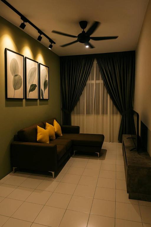 a living room with a couch and a ceiling fan at Hadi's Homestay in Sandakan