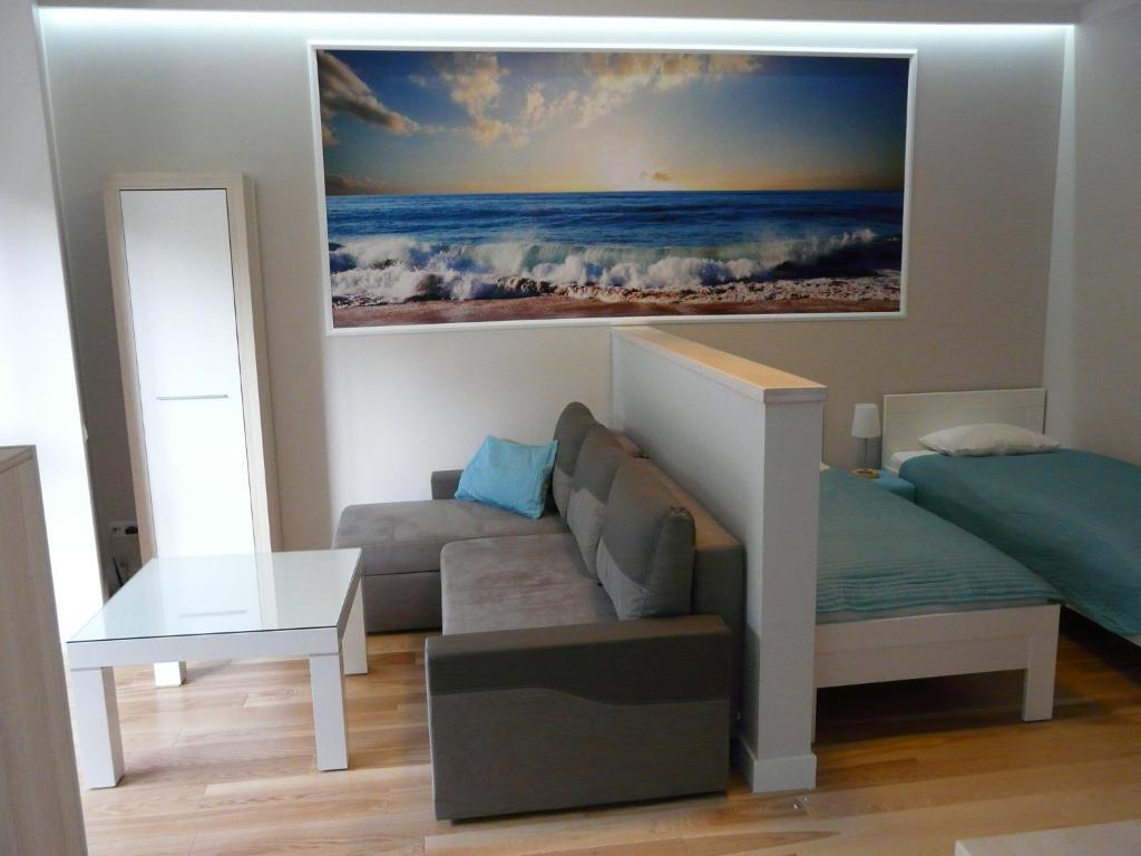 a living room with a couch and a painting on the wall at Apartament Bluesky in Świnoujście