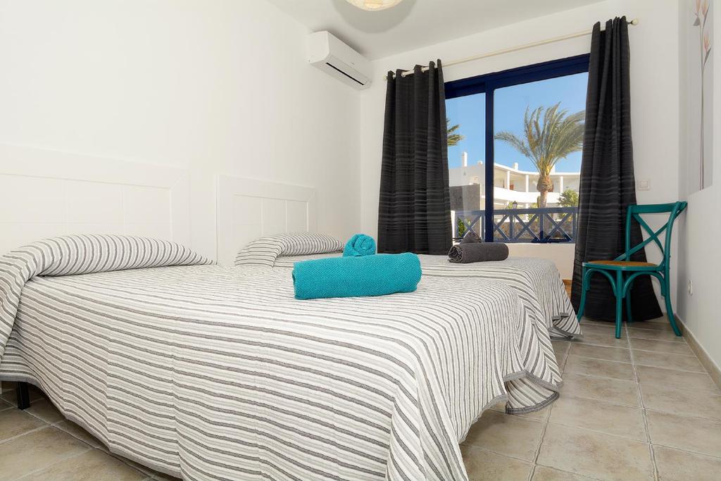 una camera da letto con un letto con un cuscino blu di Lanza Coloradas 20, heated pool a Playa Blanca