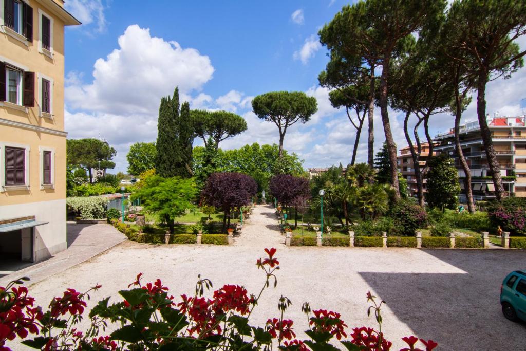 a garden with trees and flowers in a park at Ostello Villa Monte Mario in Rome
