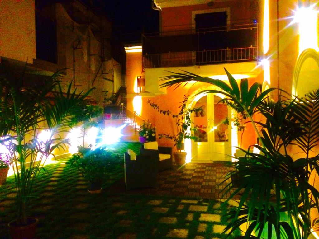 a courtyard with plants in front of a building at night at Il Principe B&B in Alì Terme