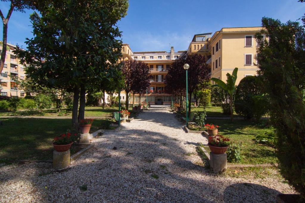 a courtyard with potted plants in front of a building at Ostello Villa Monte Mario in Rome